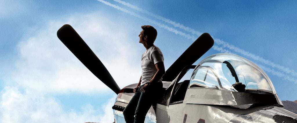 Tom Cruise leaning on an airplane in a shot from Top Gun: Maverick
