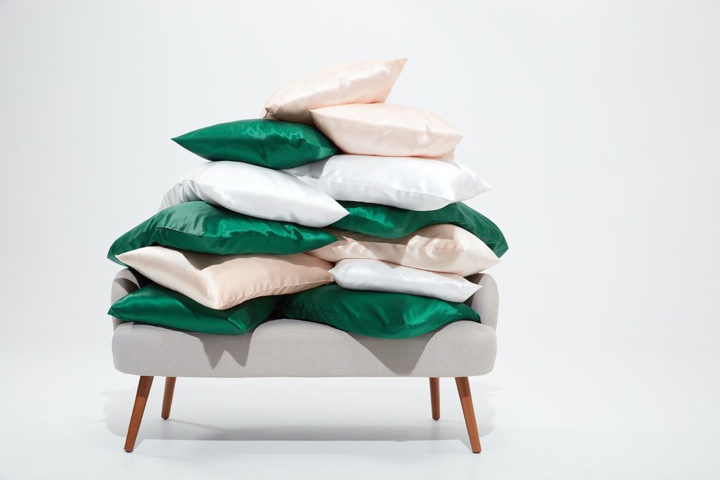 Pillows in pillowcases arranged in a pile on a gray couch