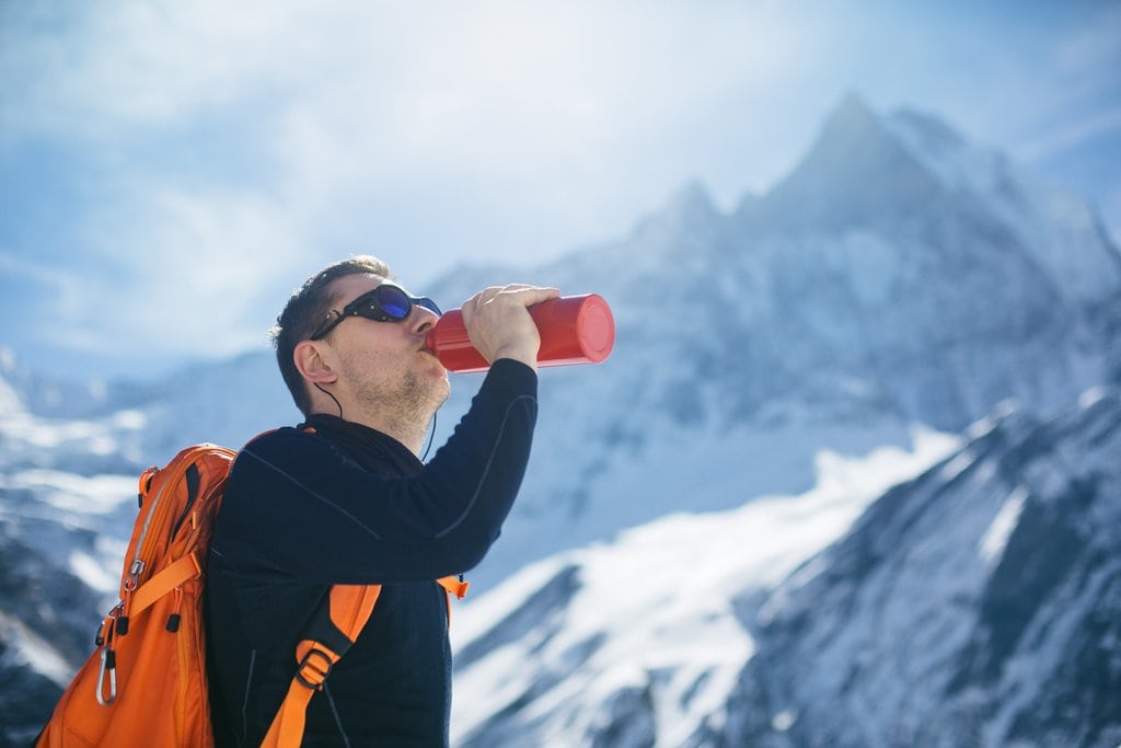A person staying hydrated in winter in the outdoors
